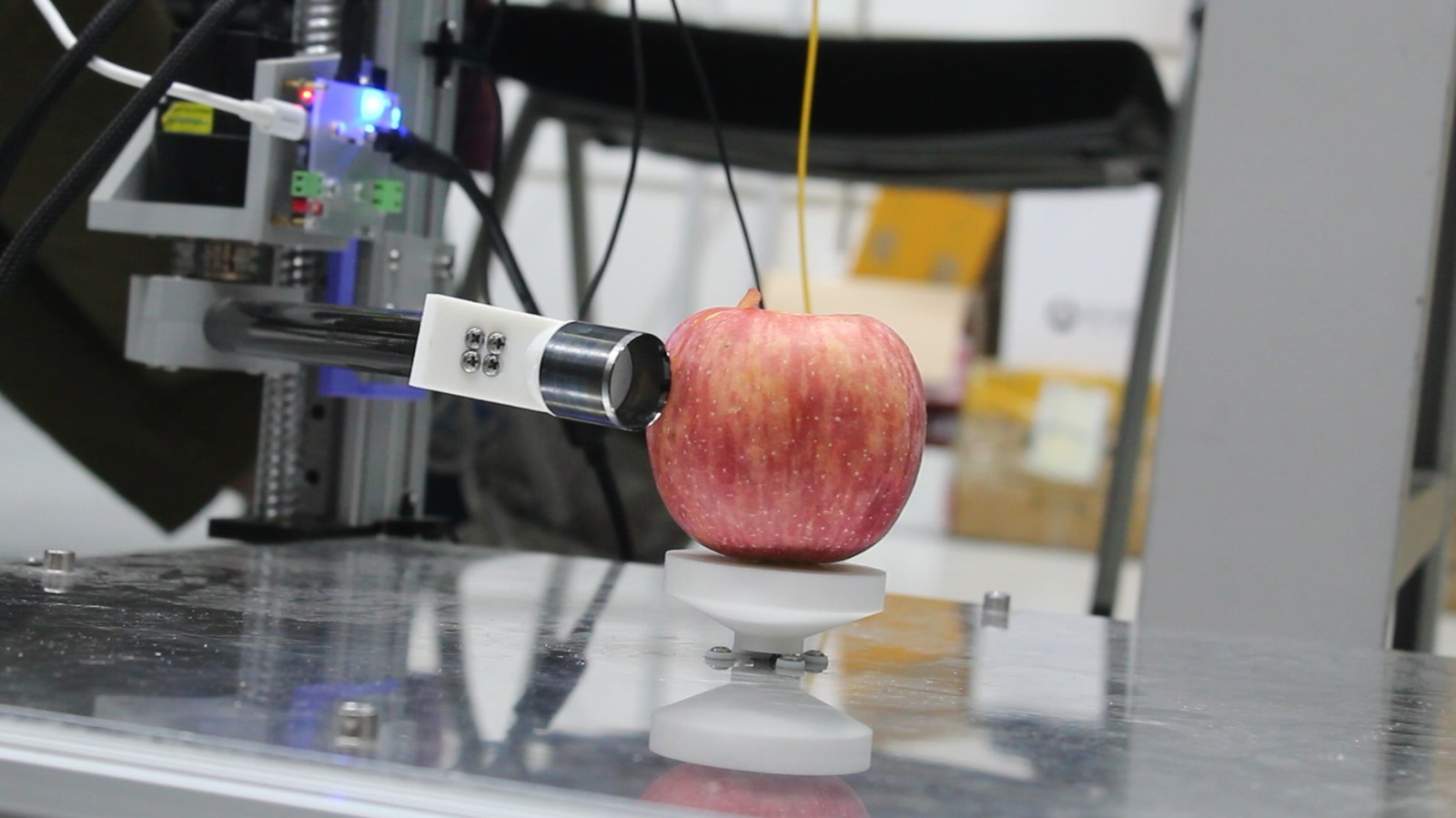 Physical peeling prototype contacting a real apple during a static test
