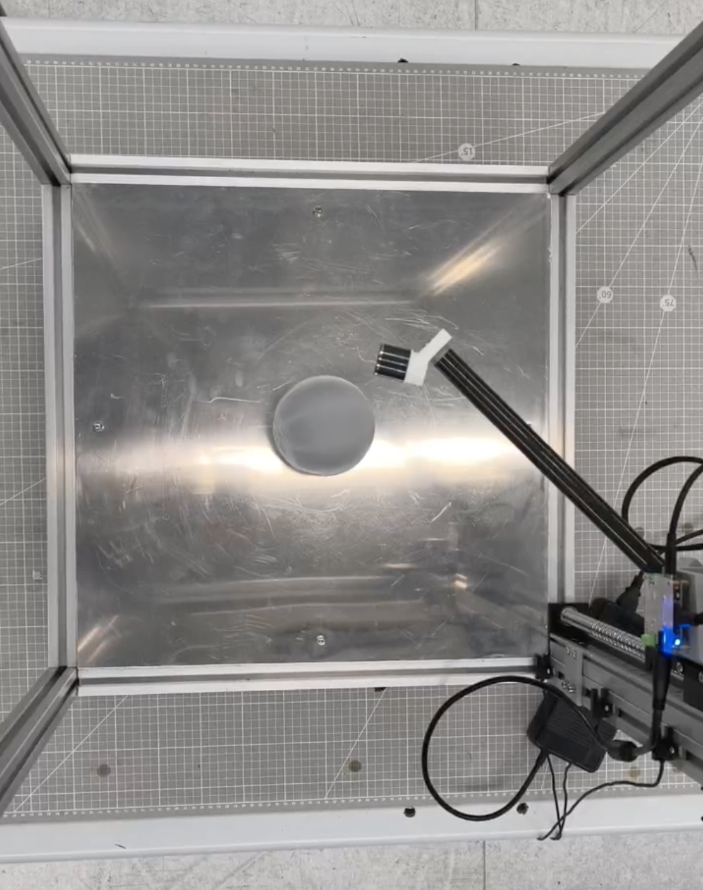Top view of the peeling prototype showing the arm sweep around the spherical test fixture