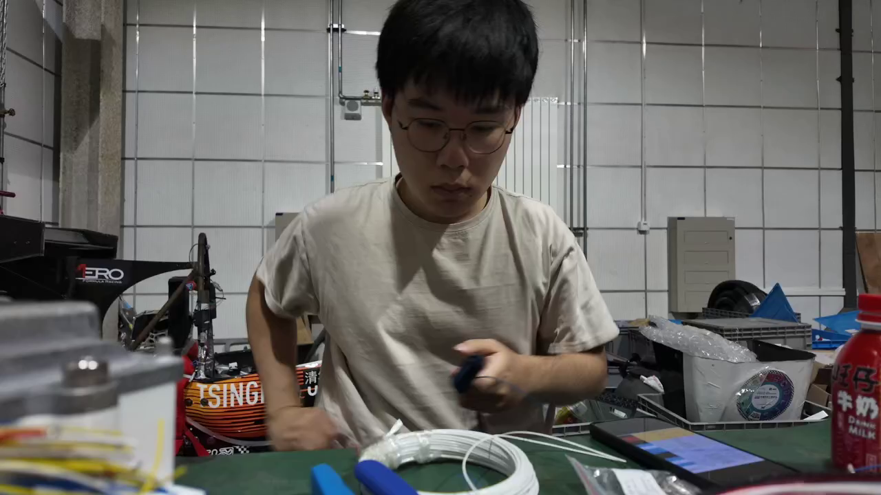 Robin Gong fabricating a Formula SAE wiring harness at a workshop bench