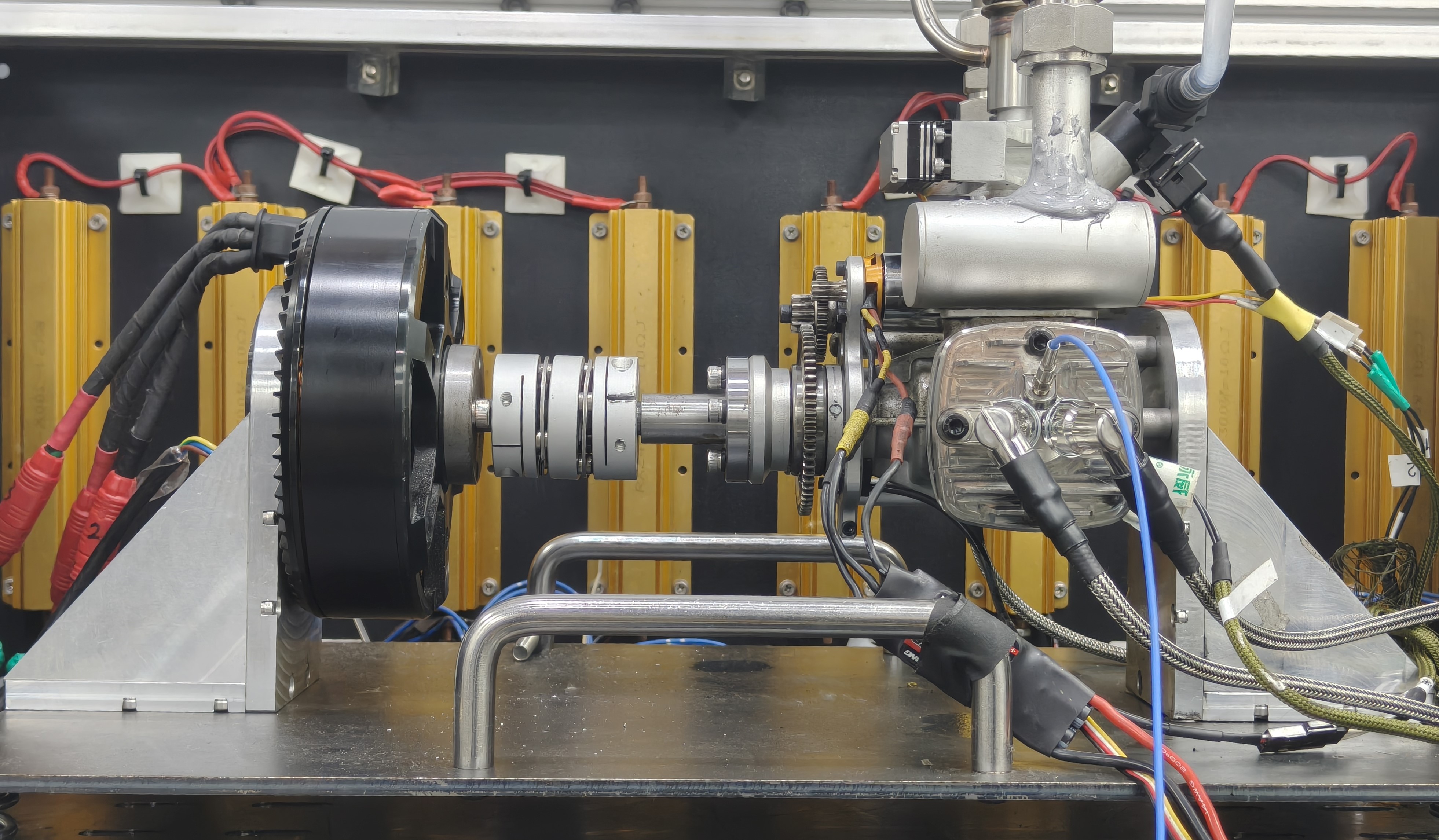 Complete GTT70 engine-generator test bench with the engine, generator, intake hardware, and instrumentation visible